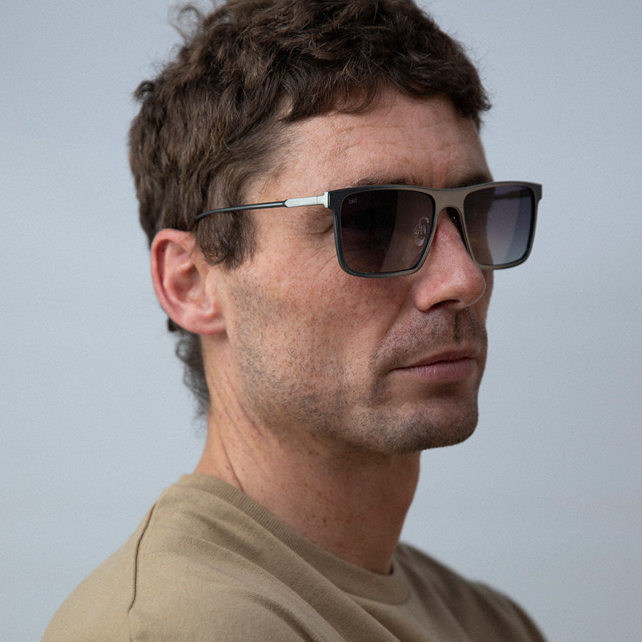 Man wearing metal rectangle sunglasses looking sideways