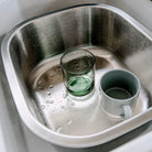 Stainless Steel Washing Up Bowl in a Kitchen sink with crockery in it. Elephant Box 